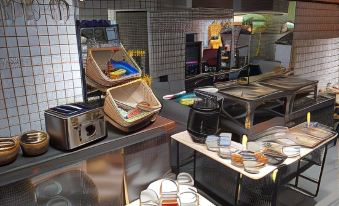 a kitchen with various appliances and dishes , including a toaster , plates , bowls , cups , and cutlery at Fabrika
