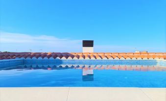 a large swimming pool with a modern , orange - tiled roof and a black - and - white box sculpture in the middle at Hotel Son Vilar