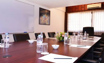 a conference room with a long table , water bottles , and papers set up for a meeting at Lavilla by Holiday Villa Cherating