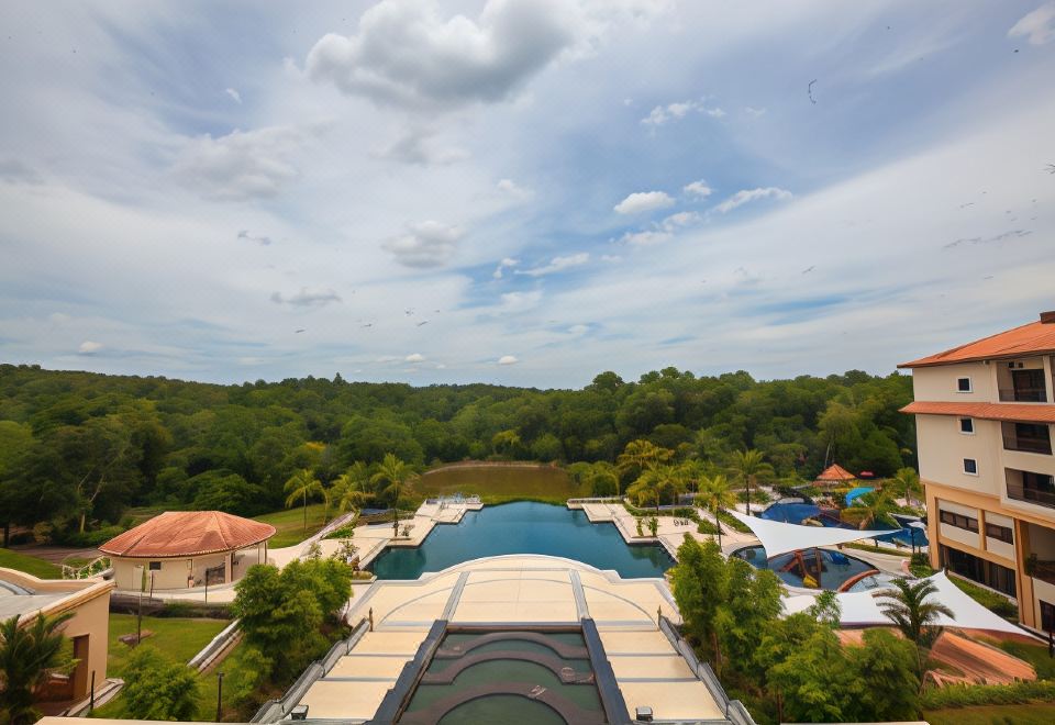 a large pool with a wooden deck and people in the water is surrounded by trees at Amverton Heritage Resort