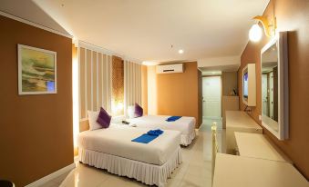 a hotel room with two beds , one on the left and one on the right side of the room at Bay Hotel Srinakarin