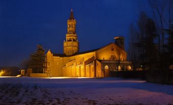 a large church with a tall bell tower is lit up at night , surrounded by snow at Hotel Majestic