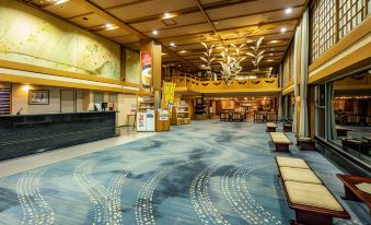 a large hotel lobby with high ceilings , multiple seating areas , and a reception desk at Zazan Minakami