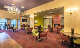a modern hotel lobby with various seating arrangements , including couches and chairs , creating a comfortable atmosphere for guests at Gloucester Robinswood Hotel, BW Signature Collection
