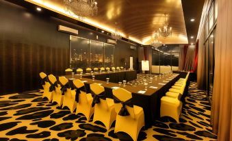 a large conference room with a long table , chairs , and chandeliers , set for a formal event at Amaroossa Hotel Bandung Indonesia