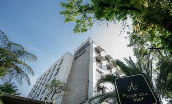"a tall building with a sign that reads "" embassy suites "" prominently displayed on the front of the building" at Amaroossa Hotel Bandung Indonesia