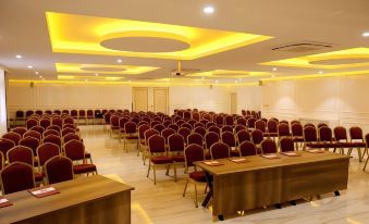a large conference room with rows of red chairs arranged in a semicircle , and a podium at the front of the room at Emirtimes Hotel&Spa - Tuzla