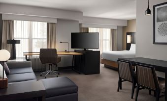a modern hotel room with a large bed , desk , and tv , as well as comfortable seating at Residence Inn Stockton