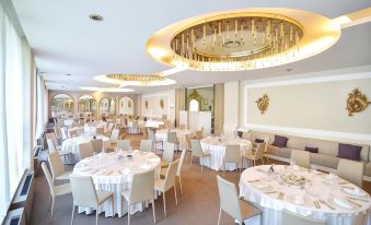 a large , elegant dining room with multiple tables and chairs set up for a formal event at Blue Dream Hotel