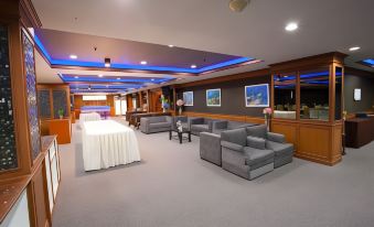 a large , empty conference room with multiple couches and chairs arranged in various positions , creating a comfortable and inviting atmosphere at Bay Hotel Srinakarin