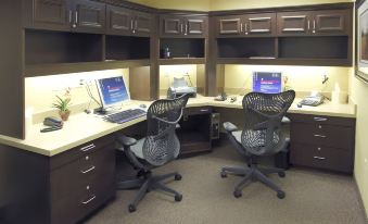 two office desks with computer monitors and chairs , one on the left and one on the right at Hilton Garden Inn Clovis