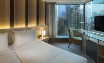 A bedroom with a double bed and a large window that overlooks the city from one side at The Royal Pacific Hotel and Towers