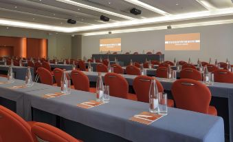 a conference room with multiple rows of chairs and tables , each equipped with glassware and water bottles at Monte-Carlo Bay Hotel & Resort