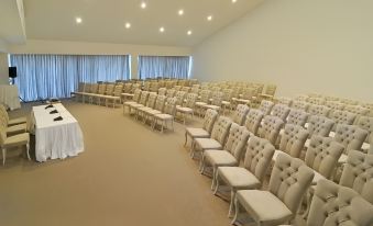 a large conference room with rows of beige chairs and white walls , ready for an event at Jiva Beach Resort - Ultra All Inclusive