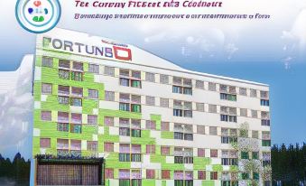"a colorful building with the words "" fortune 's "" on it , surrounded by other buildings and trees" at Fortune D Hotel Loei