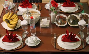 a dining table set with a variety of food items and utensils , ready for a meal at Jazz Hotel Palu