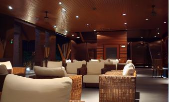 a modern living room with wooden walls , a large screen tv , and comfortable seating arrangements at Duyong Marina & Resort