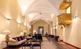 a spacious living room with high ceilings , comfortable furniture , and a staircase leading to an upper level at Convento do Espinheiro, Historic Hotel & Spa