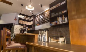 a modern coffee shop with wooden furniture , shelves filled with books , and various beverages on display at Z Hotel