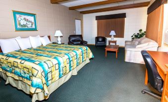 a hotel room with a bed , couch , and chairs , as well as other furniture and decorations at Wrangler Inn Mobridge