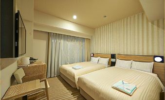 a hotel room with two beds , each made up with white sheets and blue towels , accompanied by wooden furniture at Sotetsu Fresa Inn Kamakura-Ofuna Higashiguchi