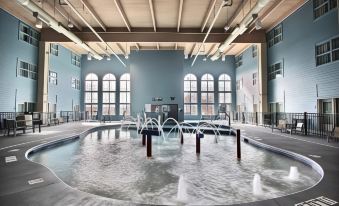 a large indoor pool with multiple hot tubs , surrounded by a spa area with jets at Hilton Garden Inn Oconomowoc