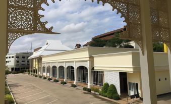 a row of white buildings with arched entrances , set against a backdrop of a cloudy sky at Amonruk  Hotel 2