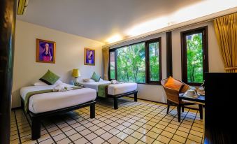 a hotel room with three beds , two of which are twin beds and one is a queen - sized bed at Baan Amphawa Resort & Spa