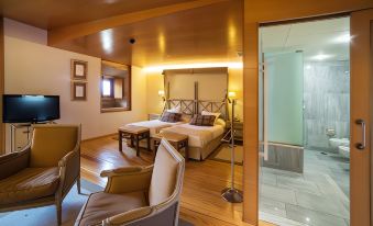 a bedroom with a bed , chair , and lamps is shown next to a bathroom with a shower at Parador de Santo Estevo
