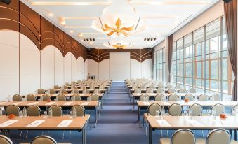 a large conference room with rows of chairs arranged in a semicircle , and a podium at the front at Na Tree Tara Riverside Resort Amphawa Damnoensaduak