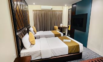 a hotel room with two beds , one on the left and one on the right side of the room at Richmond Hotel Sylhet