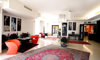 a spacious , well - lit living room with red furniture and a large rug on the floor at Best Western Cesena Hotel
