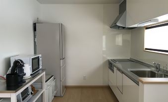 a clean and well - organized kitchen with stainless steel appliances , including a refrigerator , oven , and microwave at Ume