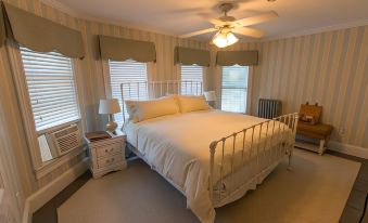 a bedroom with a large bed , two lamps on either side of the bed , and a ceiling fan at Inn at Tyler Hill