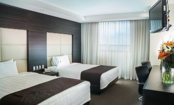 a modern hotel room with two beds , white curtains , and a dark wood headboard , ready for guests at Hotel Astor