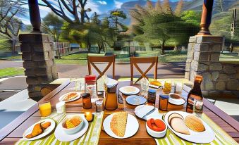 a dining table set with a variety of food items , including sandwiches , fruits , and beverages at Jungle Hut