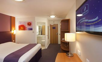 a hotel room with a bed , nightstands , and a tv , along with a desk and a chair at Premier Inn Whitehaven