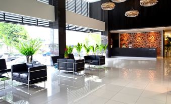 a modern hotel lobby with black and white tiled flooring , large windows , and modern furniture at Pinetree Hotel