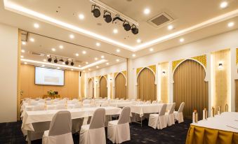 a large , empty banquet hall with multiple white tables and chairs set up for a meeting or event at Alfahad Hotel