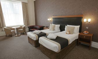 a hotel room with two beds , one on the left and one on the right side of the room at The Midland Hotel