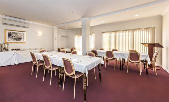 a large conference room with multiple tables and chairs arranged for a meeting or event at Ingot Hotel Perth, Ascend Hotel Collection