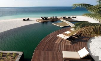 a large pool surrounded by lounge chairs and a wooden deck overlooks the ocean at a resort at Constance Moofushi