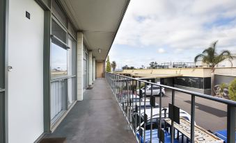 a balcony with a view of an airport and buildings , including the city skyline in the distance at Nightcap at Westside Hotel