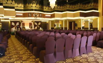 a large conference room with rows of chairs arranged in an orderly fashion , ready for a meeting or event at Tjokro Hotel Klaten