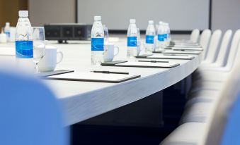 a conference room set up for a meeting , with chairs arranged in a row and water bottles placed on a table at Radisson Blu Aruba