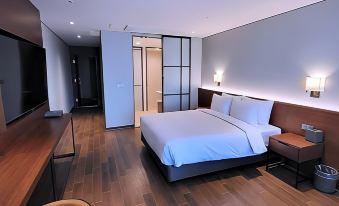 a modern bedroom with a large bed , wooden flooring , and a tv mounted on the wall at The Marevo