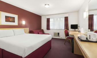a hotel room with a bed , desk , and chair , as well as a tv and other furniture at Days Inn by Wyndham London Stansted Airport