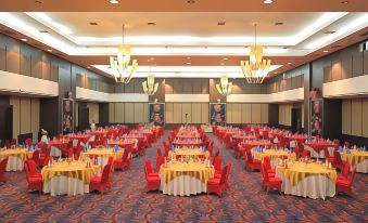 a large banquet hall filled with round tables and chairs , all set for a formal event at Sahid Bela Ternate