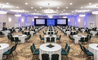 a large conference room filled with round tables and chairs , ready for an event or meeting at Penn Harris Hotel Harrisburg, Trademark by Wyndham