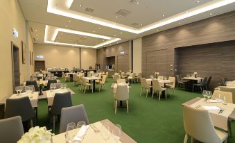 a large , empty conference room with multiple tables and chairs set up for meetings or events at Hotel Princess